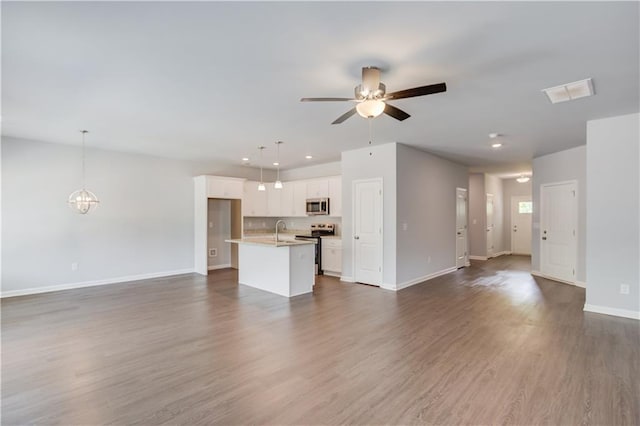 unfurnished living room featuring sink, dark hardwood / wood-style floors, and ceiling fan with notable chandelier