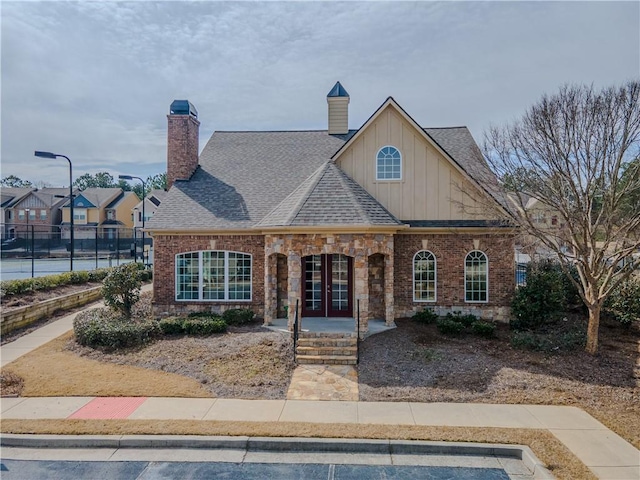 3318 Sardis Bend Dr, Buford, GA 30519 - view of front of property with board and batten siding, french doors, fence, roof with shingles, and brick siding