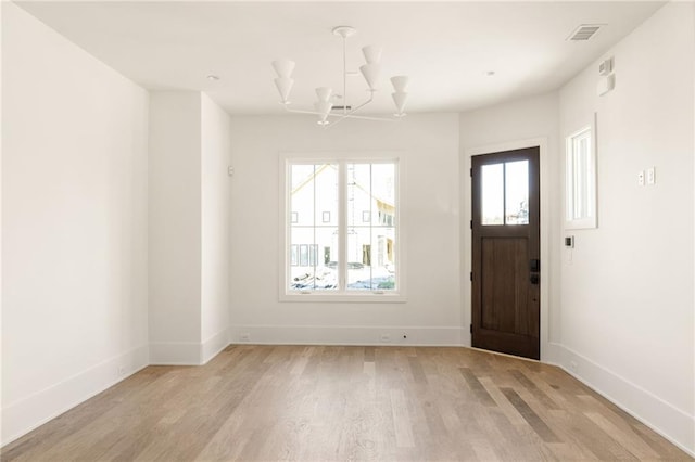 foyer entrance featuring light hardwood / wood-style floors and an inviting chandelier