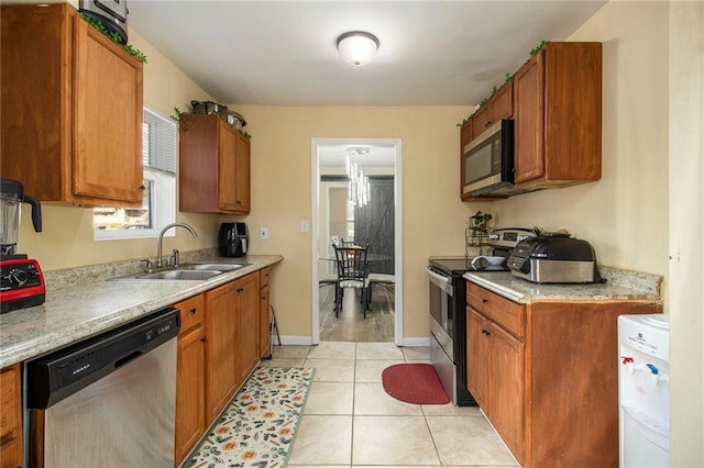 kitchen with appliances with stainless steel finishes, light tile patterned floors, and sink