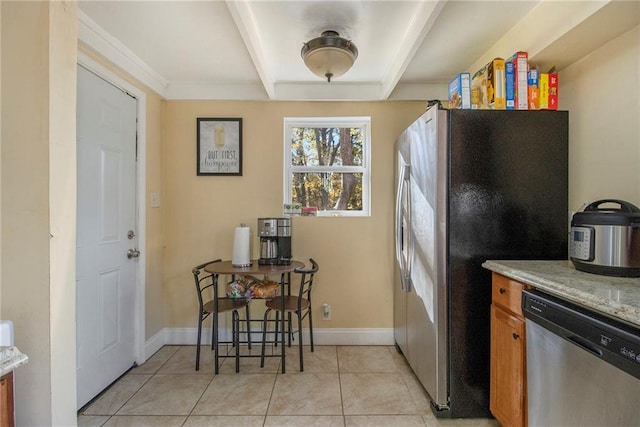 kitchen with light stone countertops, light tile patterned floors, and stainless steel appliances