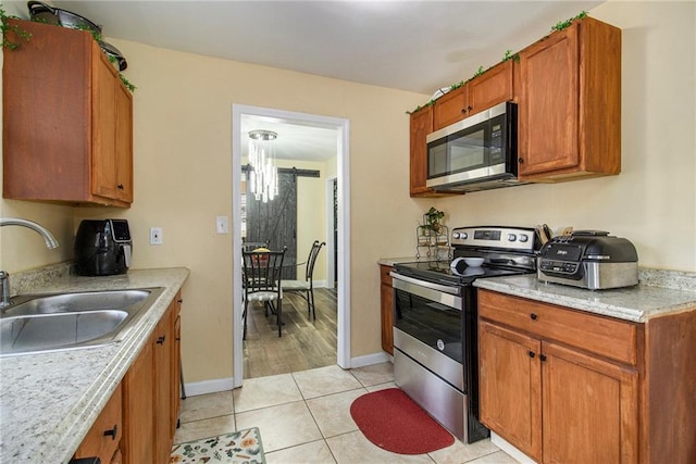 kitchen featuring appliances with stainless steel finishes, light tile patterned floors, and sink