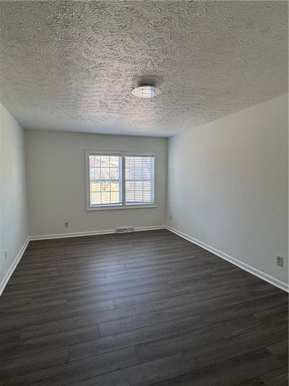 unfurnished room with dark hardwood / wood-style floors and a textured ceiling