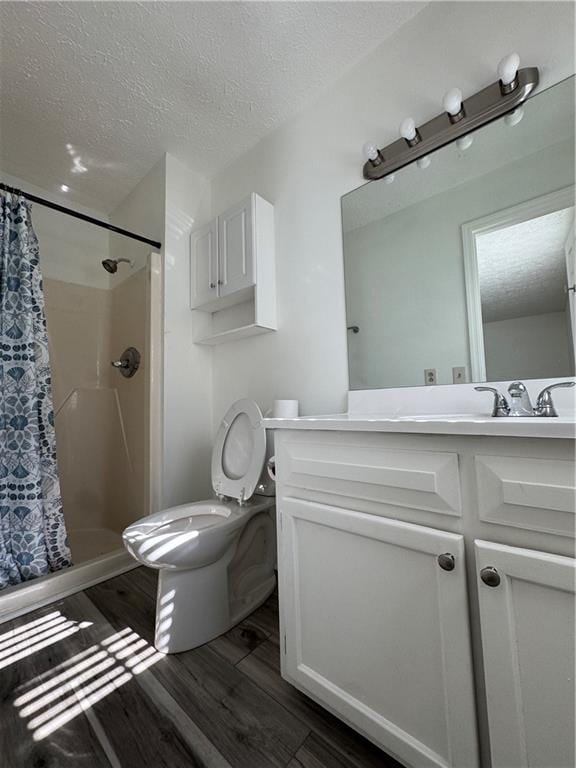 bathroom featuring hardwood / wood-style flooring, vanity, toilet, a textured ceiling, and a shower with shower curtain