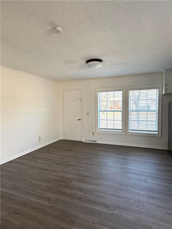 unfurnished room with dark hardwood / wood-style flooring and a textured ceiling