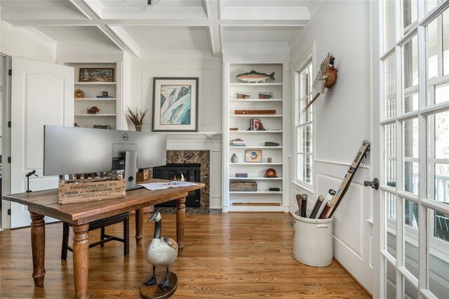 office with beamed ceiling, coffered ceiling, light wood finished floors, and a premium fireplace