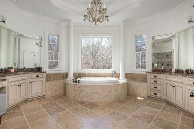 bathroom featuring ornate columns, ornamental molding, and a bath