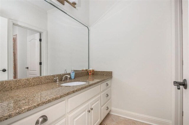 bathroom with vanity, baseboards, crown molding, and tile patterned floors