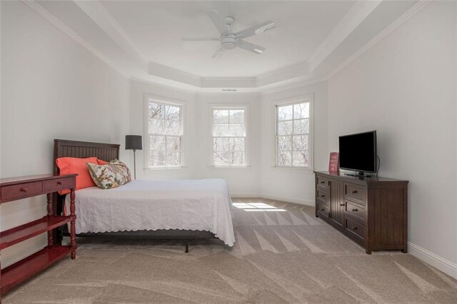 bedroom featuring baseboards, light colored carpet, ceiling fan, and a raised ceiling