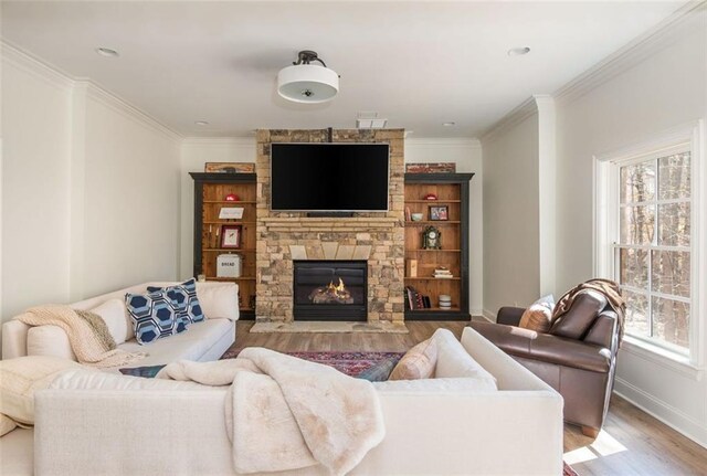 living room with light wood-style floors, baseboards, ornamental molding, and a healthy amount of sunlight