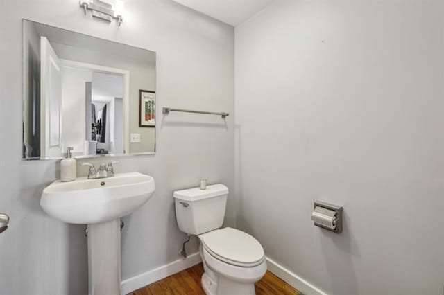 bathroom featuring sink, toilet, and wood-type flooring