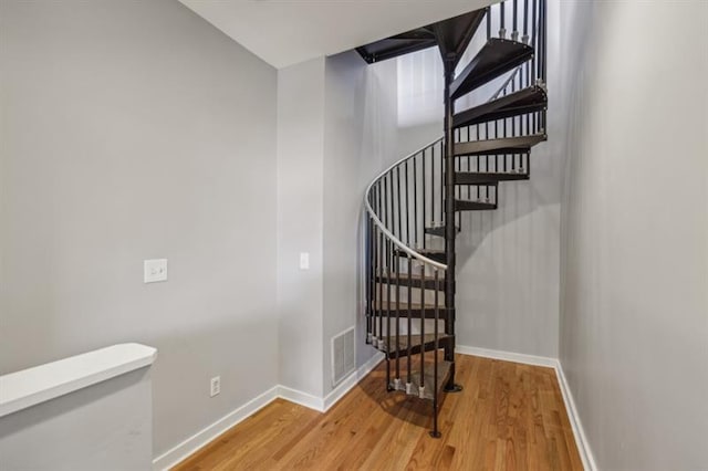 staircase with hardwood / wood-style floors