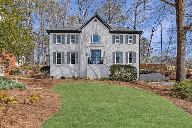 view of front of house with stucco siding and a front yard