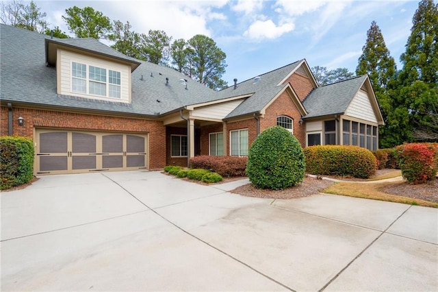 120 Chastain Rd NW Unit 1204, Kennesaw, GA 30144 - view of front facade with driveway, brick siding, an attached garage, and roof with shingles