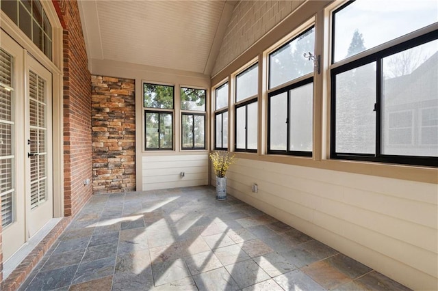 120 Chastain Rd NW Unit 1204, Kennesaw, GA 30144 - unfurnished sunroom featuring vaulted ceiling, brick wall, and stone tile floors