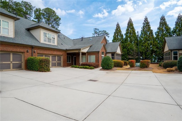120 Chastain Rd NW Unit 1204, Kennesaw, GA 30144 - view of front of property featuring driveway, an attached garage, brick siding, and roof with shingles