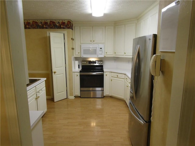5820 Elm Tree Dr, Buford, GA 30518 - kitchen with stainless steel appliances, light countertops, light wood-type flooring, white cabinets, and a textured ceiling