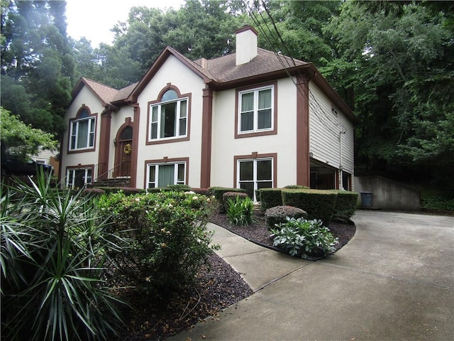 5820 Elm Tree Dr, Buford, GA 30518 - view of front facade featuring stucco siding, a chimney, driveway, and roof with shingles