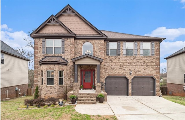 craftsman-style house featuring a front yard, a garage, brick siding, and driveway