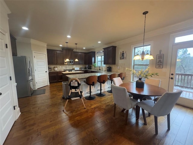 dining room with recessed lighting, a notable chandelier, dark wood-type flooring, and ornamental molding