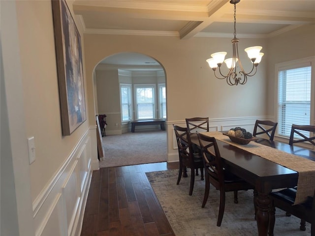 dining space with arched walkways, beam ceiling, a healthy amount of sunlight, and dark wood finished floors