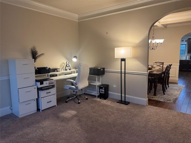 office area with crown molding, wainscoting, an inviting chandelier, arched walkways, and dark colored carpet