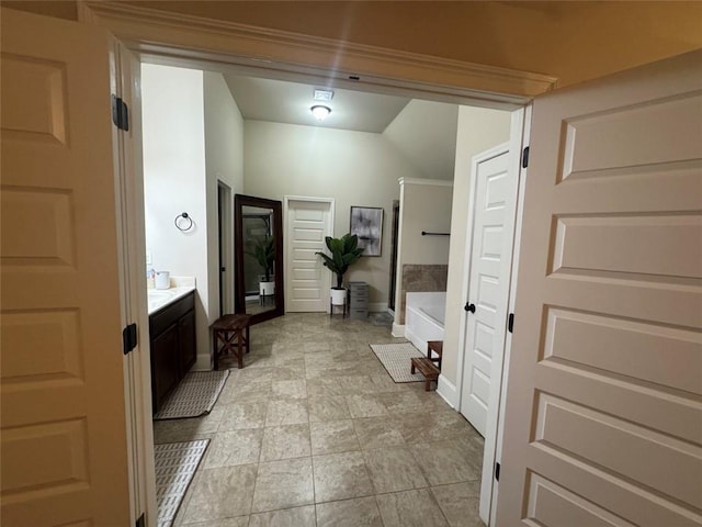 bathroom featuring a bathtub, vanity, and baseboards