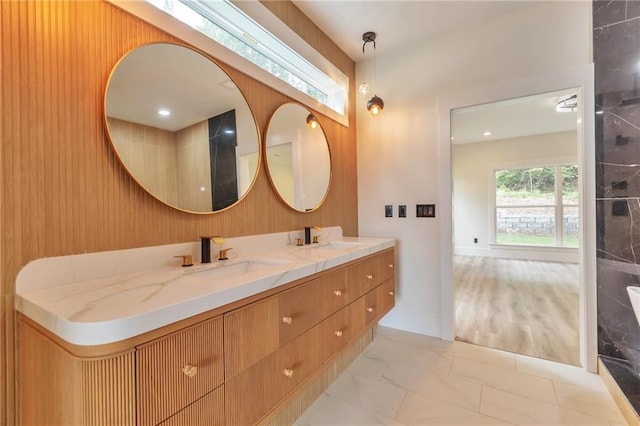 2808 S Arbor Dr, Gainesville, GA 30507 - bathroom with double vanity, marble look tile flooring, wood walls, and baseboards