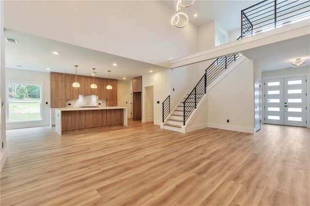 2808 S Arbor Dr, Gainesville, GA 30507 - unfurnished living room with stairs, light wood-style floors, baseboards, recessed lighting, and a towering ceiling