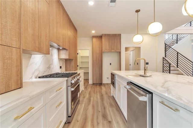 2808 S Arbor Dr, Gainesville, GA 30507 - kitchen with appliances with stainless steel finishes, a sink, light wood-type flooring, light stone countertops, and backsplash