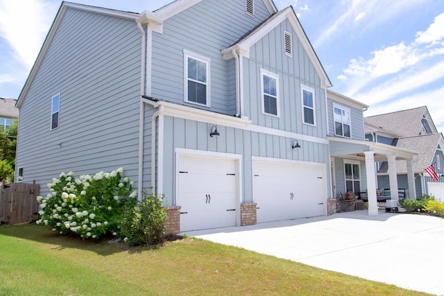 view of front of home featuring a garage, a front yard, and covered porch