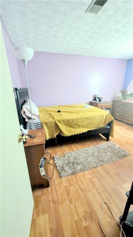 4256 Village Square Ln, Stone Mountain, GA 30083 - bedroom featuring a textured ceiling and wood finished floors