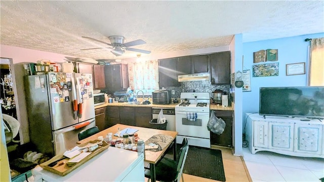 4256 Village Square Ln, Stone Mountain, GA 30083 - kitchen with appliances with stainless steel finishes, under cabinet range hood, a textured ceiling, light countertops, and a sink