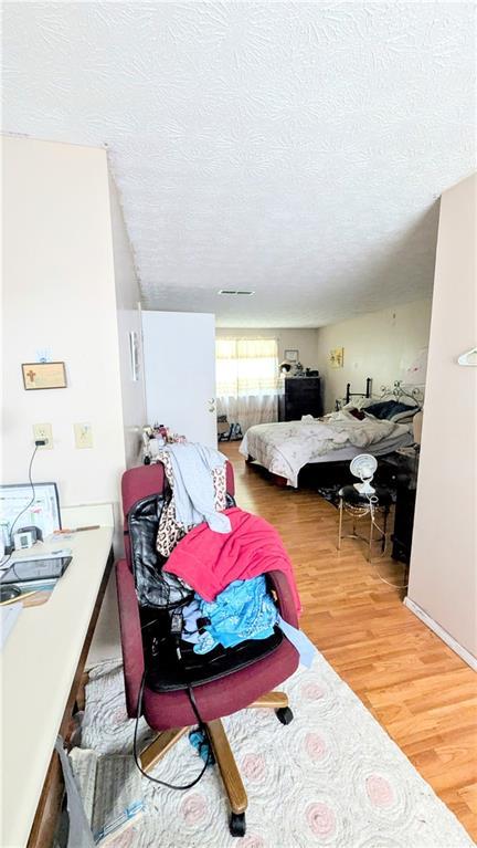 4256 Village Square Ln, Stone Mountain, GA 30083 - bedroom with wood finished floors and a textured ceiling