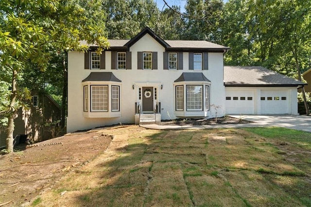 colonial home featuring a front yard, concrete driveway, and an attached garage