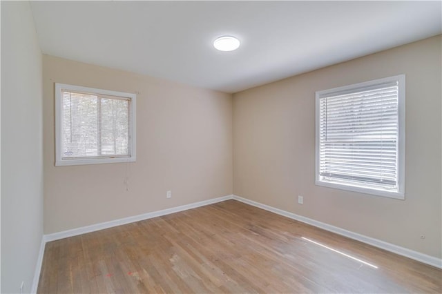 unfurnished room with light wood-style floors and baseboards