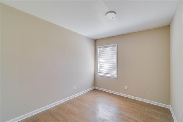 unfurnished room with light wood-style floors and baseboards