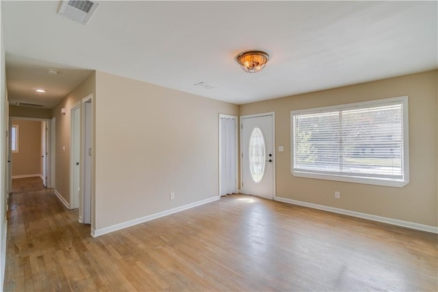 entrance foyer featuring visible vents, light wood finished floors, and baseboards