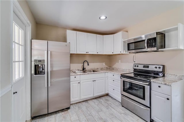 kitchen with white cabinets, appliances with stainless steel finishes, and a sink
