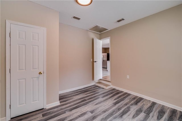 spare room with visible vents, dark wood finished floors, and baseboards