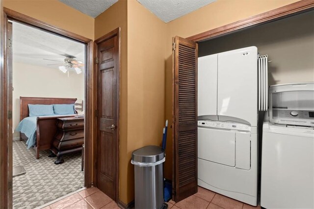 clothes washing area with a textured ceiling, laundry area, light tile patterned floors, and ceiling fan