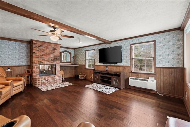 unfurnished living room featuring a wainscoted wall, a textured ceiling, and wallpapered walls