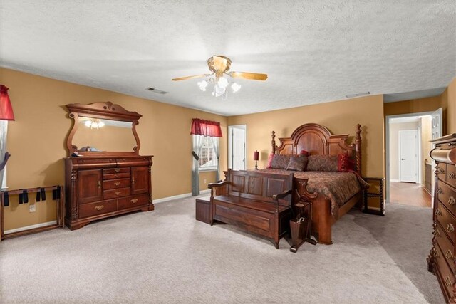 bedroom with light colored carpet, visible vents, and a textured ceiling