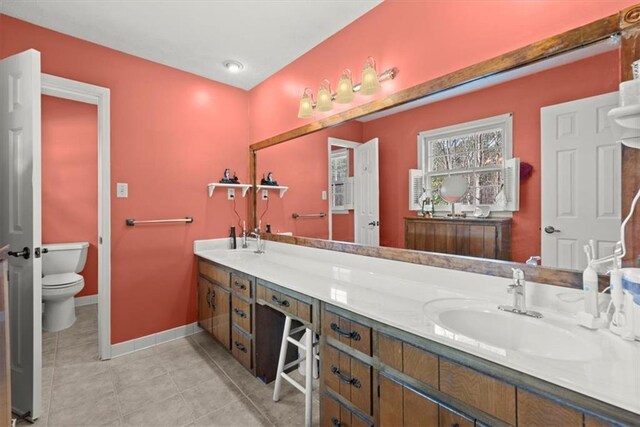 full bathroom featuring tile patterned flooring, toilet, a sink, baseboards, and double vanity