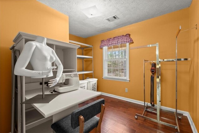 office featuring dark wood-style floors, baseboards, visible vents, and a textured ceiling