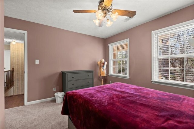 carpeted bedroom featuring a ceiling fan and baseboards