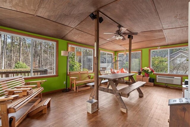sunroom / solarium featuring ceiling fan, wooden ceiling, and a wall unit AC