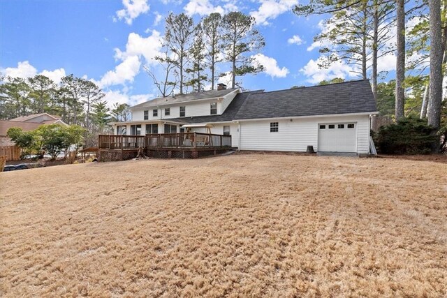 rear view of house with a deck and an attached garage