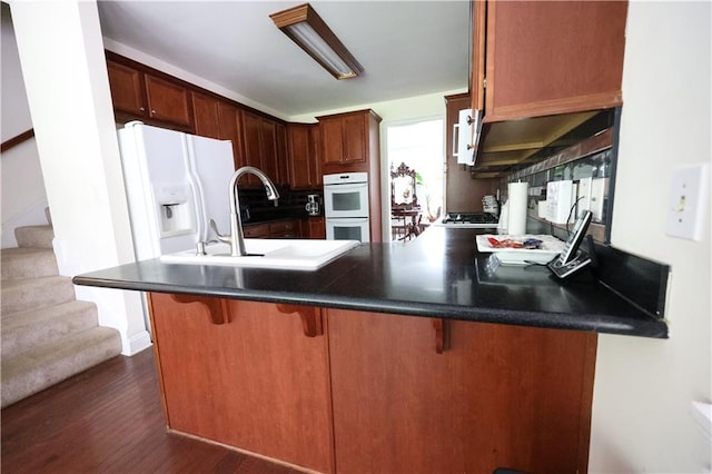 5452 Old Dalton Rd NE, Calhoun, GA 30701 - kitchen featuring white double oven, dark wood finished floors, a peninsula, and dark countertops