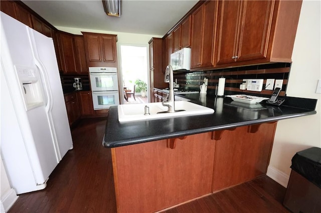 5452 Old Dalton Rd NE, Calhoun, GA 30701 - kitchen featuring white appliances, a peninsula, dark wood finished floors, and tasteful backsplash
